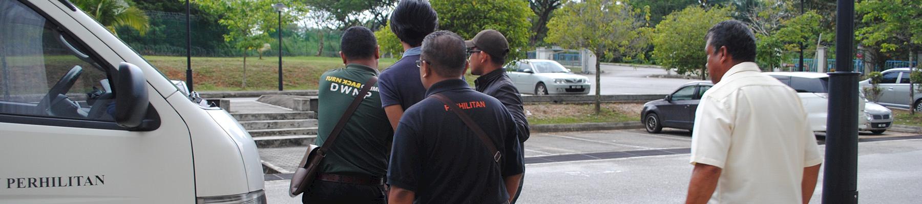 Two ex-Customs officers are escorted from court in Malaysia following sentencing for possession of protected wildlife species