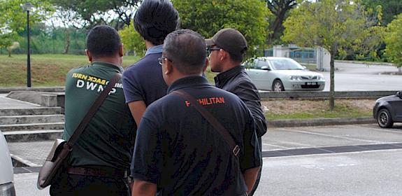 Two ex-Customs officers are escorted from court in Malaysia following sentencing for possession of protected wildlife species