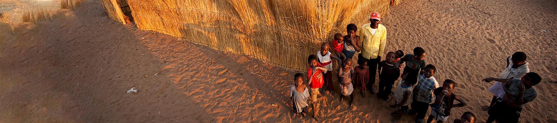 Community members standing in front of their home in the Zambezi Region