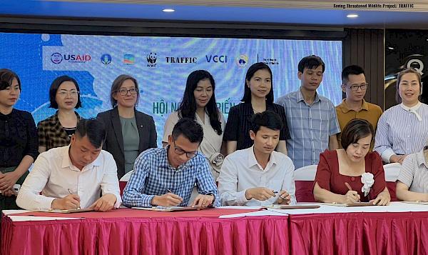 Tourism industry representatives signing a pledge to tackle illegal wildlife trade.